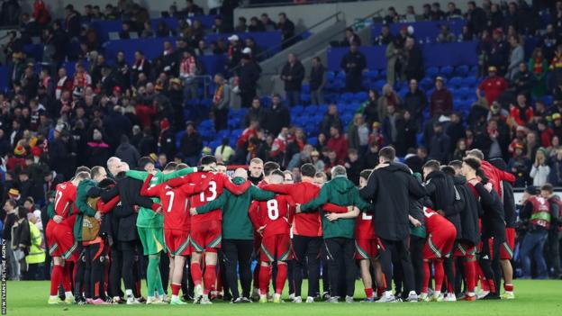 Wales players gathered after defeat to Poland