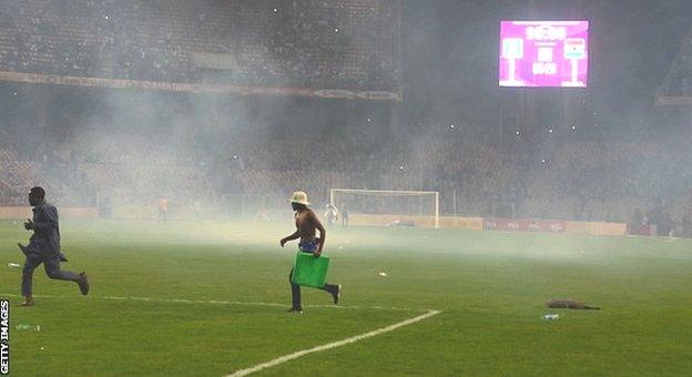 Fans on the pitch at the Moshood Abiola National Stadium