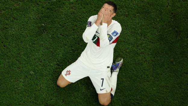 An aerial shot of Cristiano Ronaldo on his knees on the pitch with his hands over his face