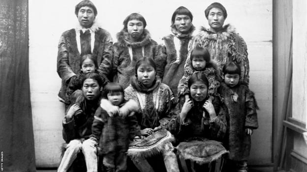 An Eskimo group of men, women, and children dressed in fur coats in Port Clarence, Alaska in 1894. Location: Port Clarence, Alaska.
