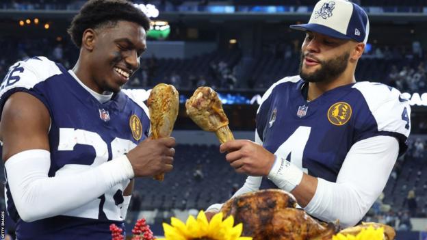 DaRon Bland and Dak Prescott each eat a turkey leg after the Dallas Cowboys' 2023 Thanksgiving game