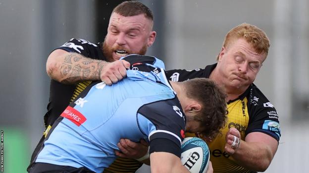 Dragons prop Lloyd Fairbrother (left) and hooker Bradley Roberts (right) tackle a Cardiff attacker during a local derby in October 2023