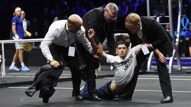 A protester is taken off the court during the Laver Cup