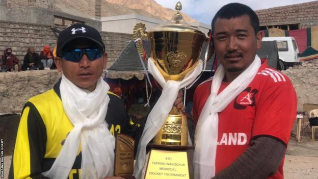 Skalzang Kalyan Dorjey - a cricketer and tour guide in India - with Stanzing Namgail - a monk from Thikse Monastery - celebrating winning the ninth Tsering Wangchuk memorial cricket tournament