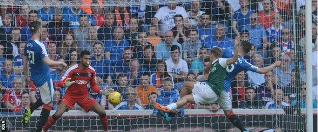 Hibs' Jason Cummings has a volley blocked by Lee Wallace at Ibrox