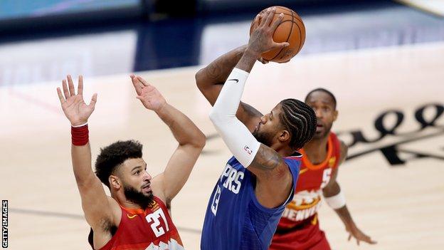 Los Angeles Clippers star Paul George shoots over Denver Nuggets guard Jamal Murray