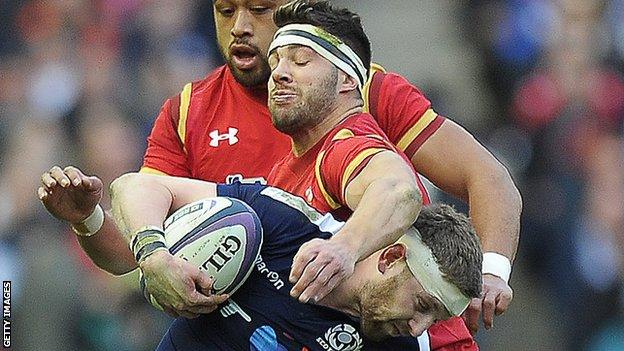 Scotland's fly-half Finn Russell is tackled by Wales scrum-half Rhys Webb