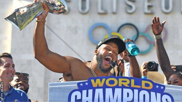Aaron Donald holds aloft the Lombardi trophy after the Los Angeles Rams' trophy parade