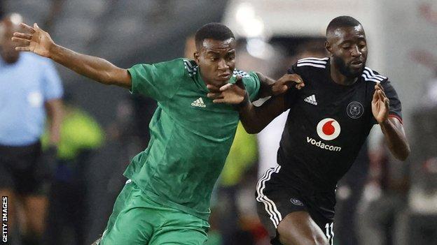 Ahlis Muayid Jadour of Al Ahly Tripoli (left) vies the ball with Orlando Pirates' Deon Hotto