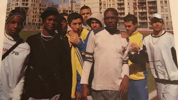 Ibrahima Traore and a group of childhood friends pose on the pitch at the centre of their neighbourhood