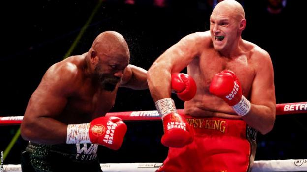 Tyson Fury punches Derek Chisora during his WBC heavyweight rubric  defence