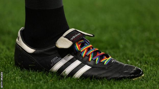 A Premier League official wears rainbow laces on his boots
