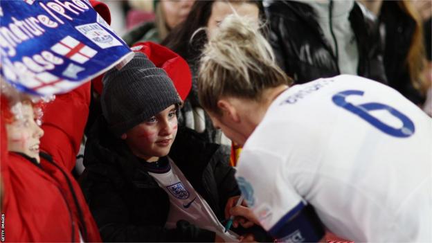 England's Millie Bright signs autographs after the win over Belgium on Friday