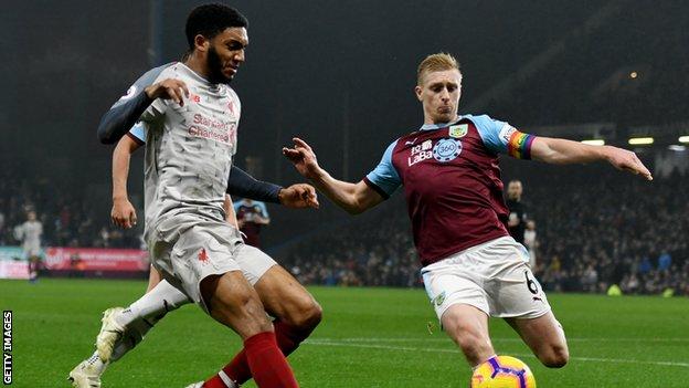 Liverpool defender Joe Gomez goes to challenge Burnley captain Ben Mee (right) for the ball during a Premier League match at Turf Moor
