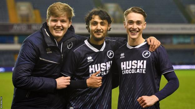 Millwall players pose for a photo on the pitch after their win against Chelsea