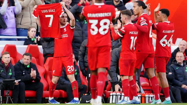Liverpool's players applaud as Diogo Jota celebrates his goal by holding up a shirt with the name of team-mate Luis Diaz on it