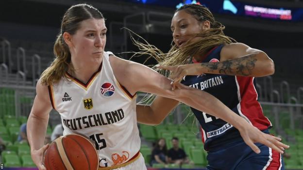 Germany's Luisa Geiselsoeder holds the ball and fends off Great Britain's Sydney Wallace
