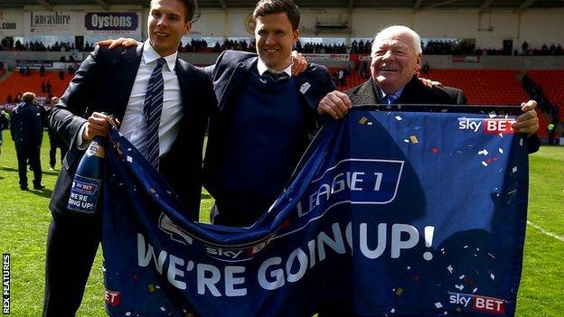 Wigan Athletic manager Gary Caldwell (centre) celebrates with chairman David Sharpe (left) and owner Dave Whelan