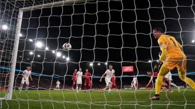 Poland goalkeeper watches ball go into net