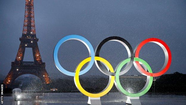 The Olympic rings lit up in front of the Eiffel Tower