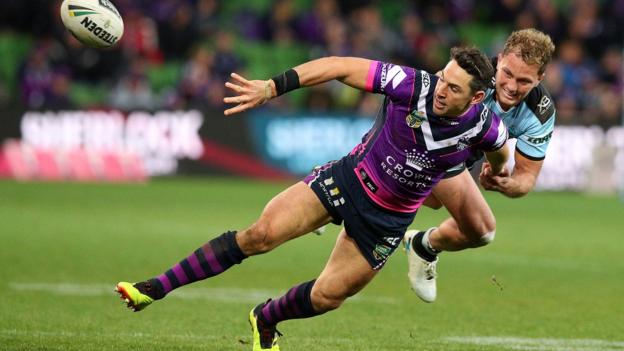 MELBOURNE, AUSTRALIA - AUGUST 12: Billy Slater of the Storm (L) passes as he is tackled during the round 22 NRL match between the Melbourne Storm and the Cronulla Sharks at AAMI Park on August 12, 2018 in Melbourne, Australia. (Photo by Graham Denholm/Getty Images)