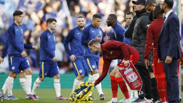Liverpool captain Jordan Henderson lays down a wreath in suport of Ukraine