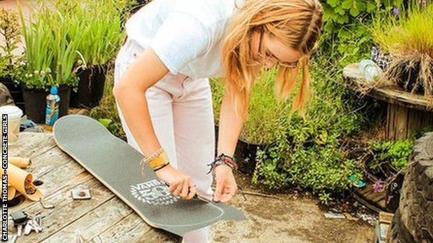 A woman looking after her skateboard