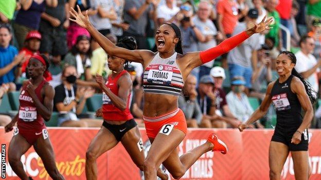 Gabrielle Thomas throws her arms wide in celebration as she crosses the line