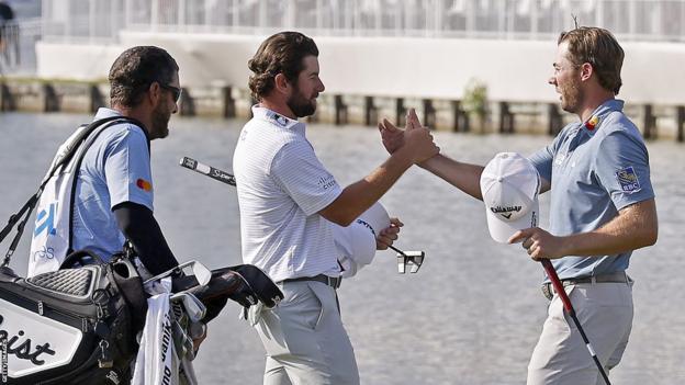Sam Burns shakes hands with Cameron Young