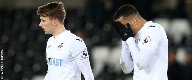 Dejected Tom Carroll and Martin Olsson after Swansea's home defeat by Tottenham