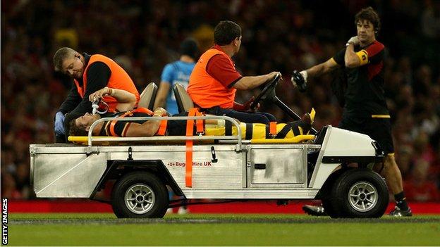 Leigh Halfpenny is taken from the field on a stretcher after rupturing a cruciate knee ligament while playing for Wales against Italy in September 2015