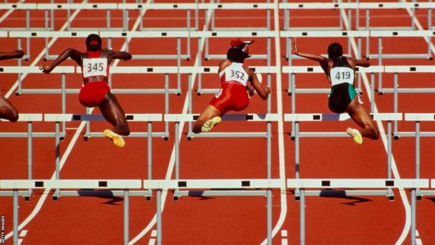 Generic shot of athletes jumping hurdles on the track