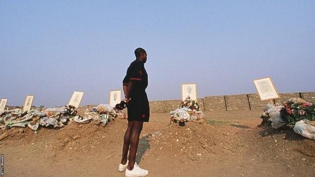 Zambia captain Kalusha Bwalya stands and looks at graves of his team-mates
