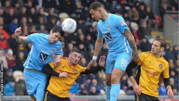 Peter Vincenti of Coventry City beats Padraig Amond of Newport County to the ball