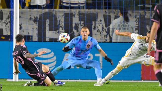 Lionel Messi scores a goal beyond LA Galaxy goalkeeper John McCarthy