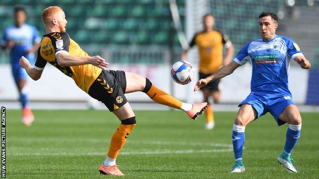 Newport's Ryan Taylor challenges Barrow's Mike Jones