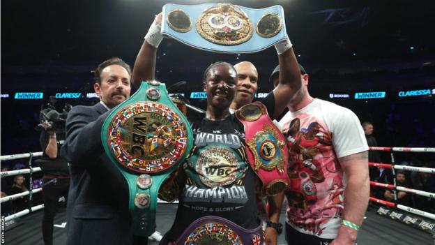 Claressa Shields posing with each  4  middleweight belts