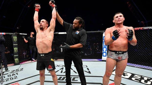 Robert Whittaker, izquierda, vence a Darren Till de Gran Bretaña, derecha