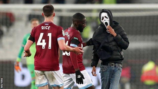 West Ham's Arthur Masuaku and Declan Rice attempt to remove a pitch invader at London Stadium on Wednesday night