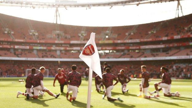 Arsenal players warm up at the Emirates