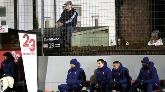 Fans watch the game from outside the stadium behind Tottenham Hotspur manager Jose Mourinho