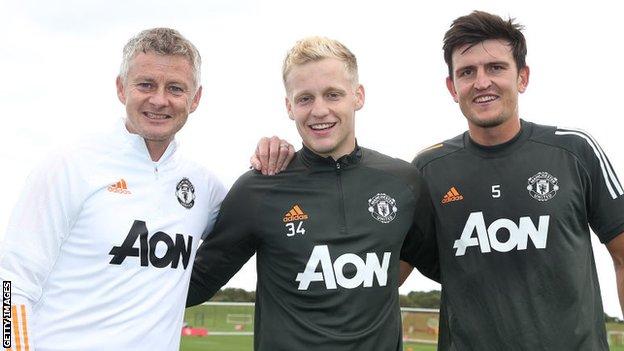 Donny van de Beek poses with Manchester United manager Ole Gunnar Solskjaer and captain Harry Maguire