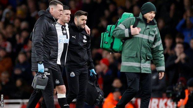 Ciaran Clark is helped off the field by the Newcastle medical staff