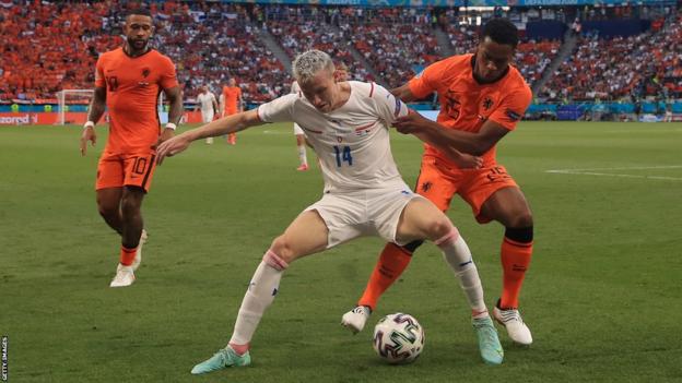 Jakub Jankto, playing for the Czech Republic in a white change strip, holds of the challenge of Jurrien Timber of the Netherlands during their last 16 match at Euro 2020