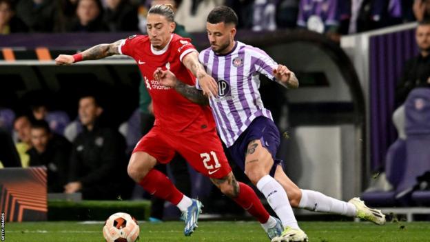Kostas Tsimikas of Liverpool competing with Aron Donnum of Toulouse