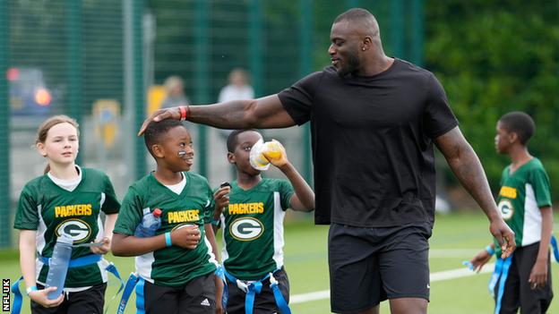 Efe Obada with children at the UK's national championships for flag football