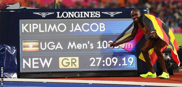 Jacob Kiplimo poses in front of his new Commonwealth Games 10,000m record