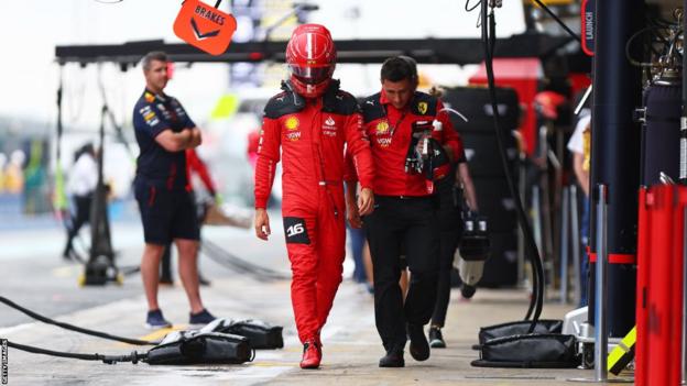 Charles Leclerc walks in the Barcelona pit lane