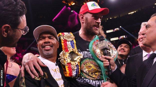 SugarHill Steward grins with Tyson Fury's arm around him