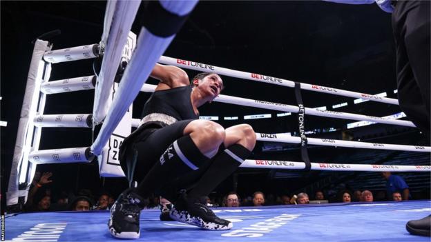 Ramla Ali is on the canvas against he ropes